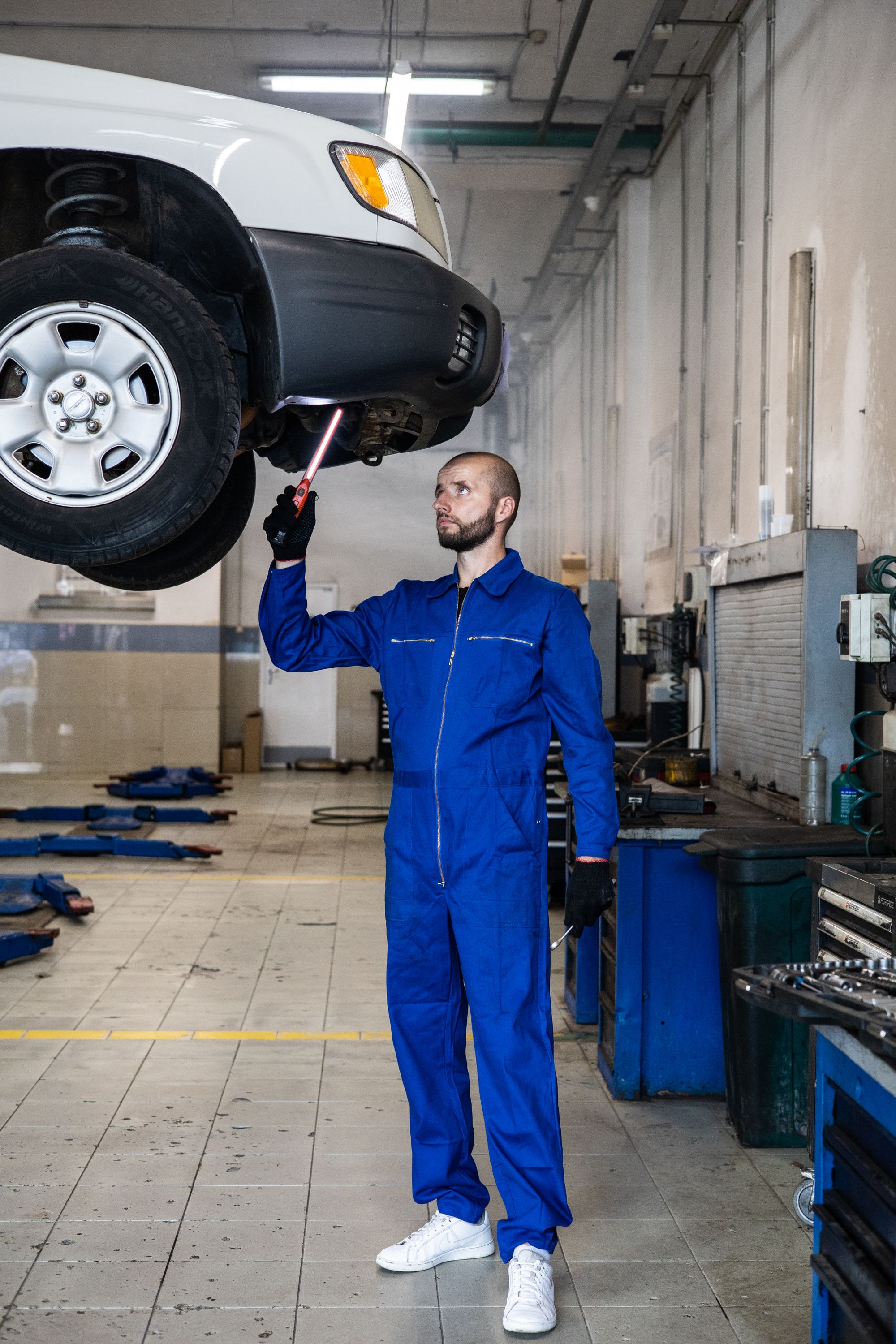 Mechanik kontroluje podvozok vozidla na zdviháku